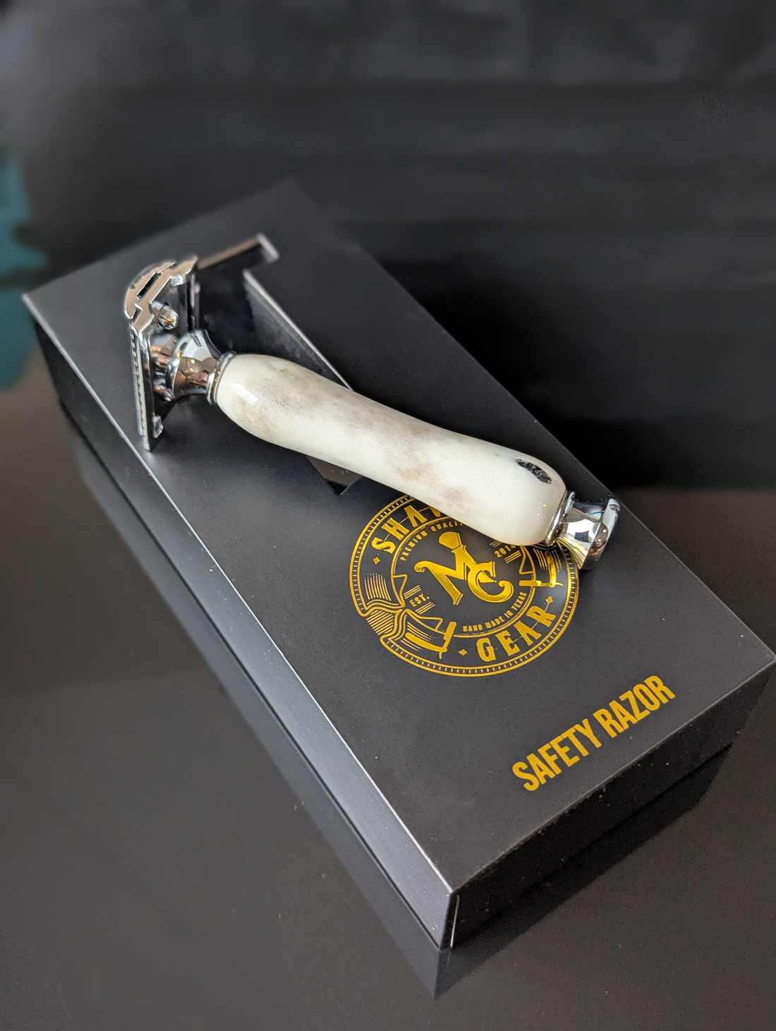 top view of a hand-crafted safety razor with an antler handle from mc shave gear with packaging