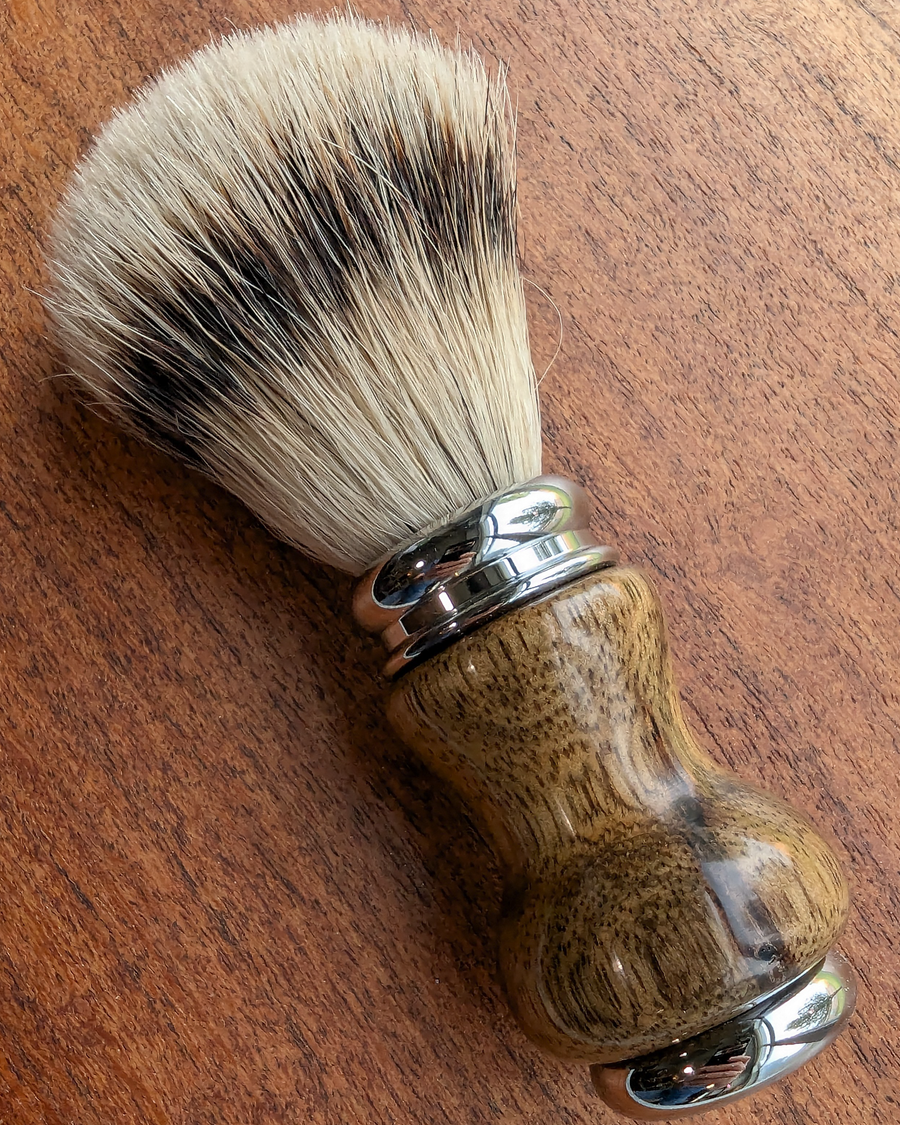 Silvertip badger shave brush with black limba handle on a slab of mesquite