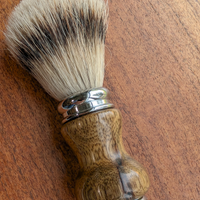 Silvertip badger shave brush with black limba handle on a slab of mesquite