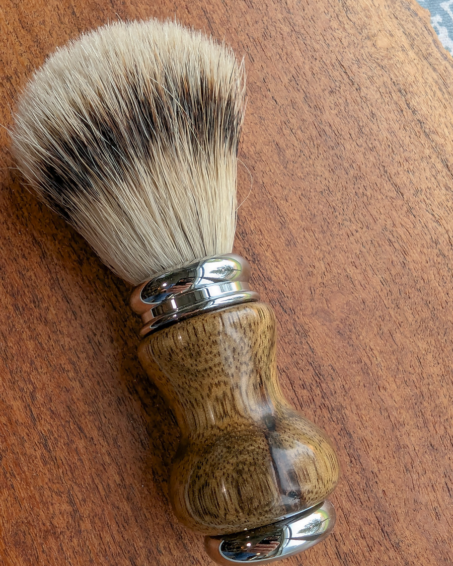 Silvertip badger shave brush with black limba handle on a slab of mesquite