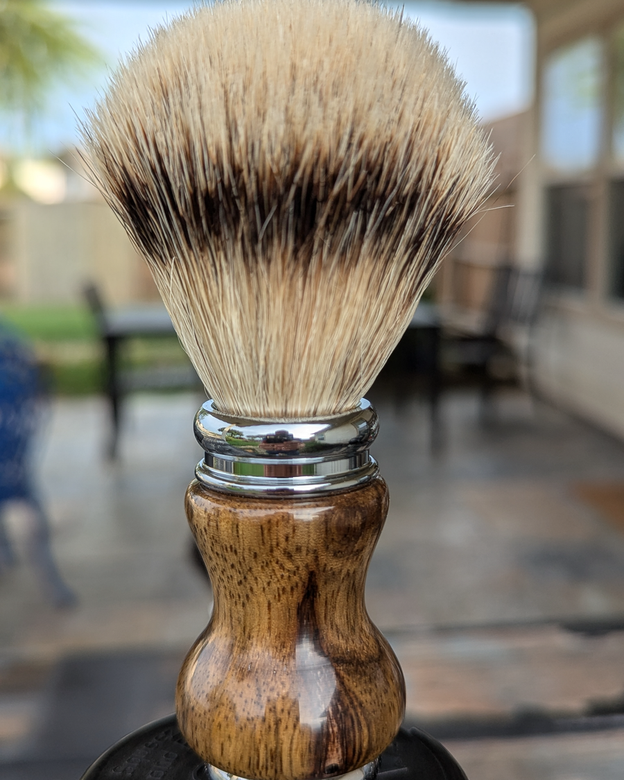 Silvertip badger shave brush with black limba handle outside on the patio